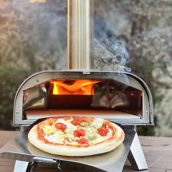 A pizza oven with a pizza sitting on top of it.
