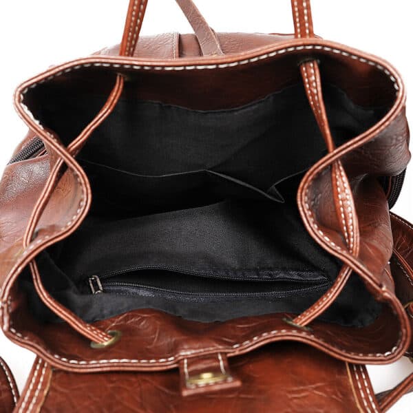 The inside of a brown leather backpack.