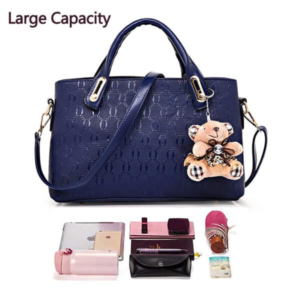 A blue handbag with a teddy bear and other accessories.