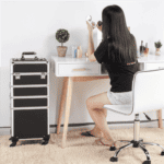 A woman sitting at a desk applying makeup.