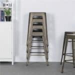 Stacked metal stools against a white wall in a minimalist room setting.