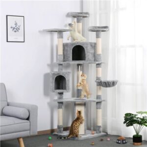 Three cats playing on a multi-level cat tree in a living room.