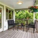 A cozy porch with a seating area overlooking greenery.