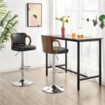 Modern kitchen nook with bar stools and a square table, accented by minimalist artwork and fresh flowers.