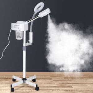A portable garment steamer emitting steam on a wooden floor against a dark wall.