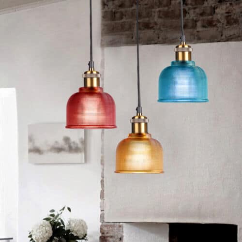 Three colorful glass pendant lights hanging above a fireplace.