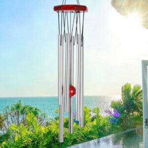 A wind chime on a balcony overlooking the ocean.