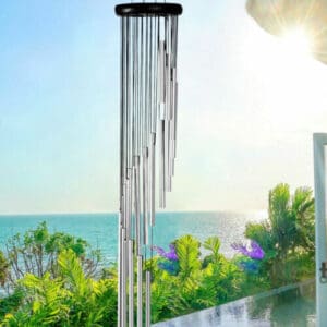 A wind chime sitting on a balcony overlooking the ocean.