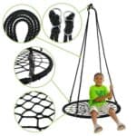 A child is sitting on a black net swing.