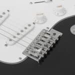 A close up of a black and white electric guitar.