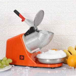 An orange ice cube maker next to a bowl of fruit.