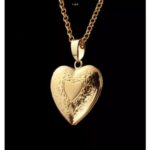 A gold heart locket necklace on a black background.