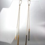 A pair of gold dangling earrings.