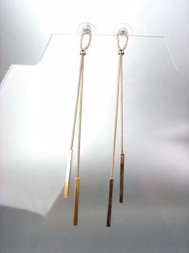 A pair of gold dangling earrings.