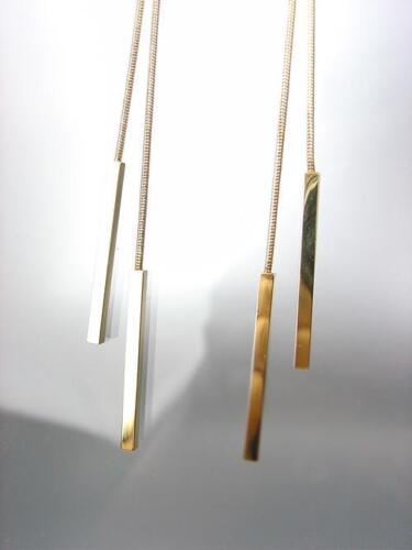 A pair of gold bar earrings hanging from a string.