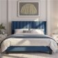 A blue upholstered bed in a bedroom.