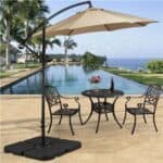 A patio umbrella with a table and chairs next to a pool.