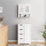 A white cabinet with two drawers and a plant on the wall.