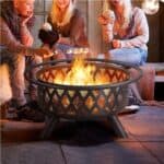 A group of people sitting around a fire pit.