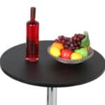 A bowl of fruit and a bottle of wine on a table.