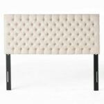 A tufted headboard with black metal legs.