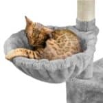 A cat is sleeping on a scratching post.