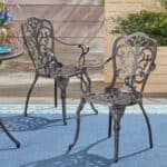 Wrought iron patio chairs on a blue rug.