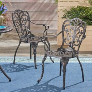Wrought iron patio chairs on a blue rug.