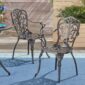 Wrought iron patio chairs on a blue rug.