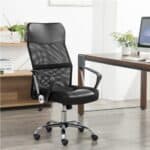 A black mesh office chair in front of a wooden desk.