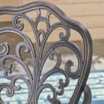 An ornately carved patio chair on a patio.