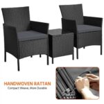 A black rattan furniture set with two chairs and a table.