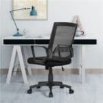 A black mesh office chair in front of a desk.