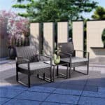 A black wicker patio furniture set on a patio.