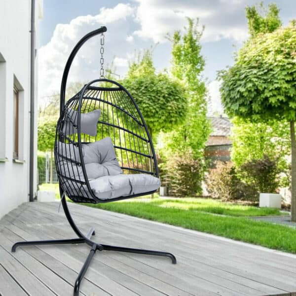 A black hanging chair on a wooden deck.