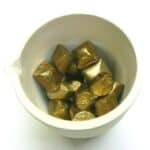 Gold nuggets in a white bowl.