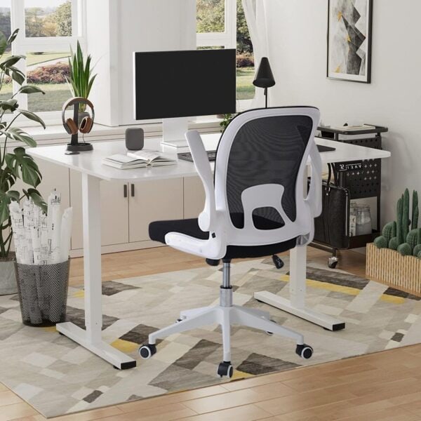 A modern home office with a white desk, swivel chair, and desktop computer.