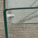 A glass coffee table on a carpeted floor.