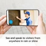 Smartphone displaying a delivery person at the door through a video doorbell app with the caption "see and speak to visitors from anywhere in rain or shine.