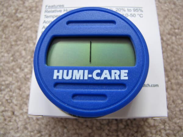 A blue humi-care humidity indicator card placed on top of its packaging.