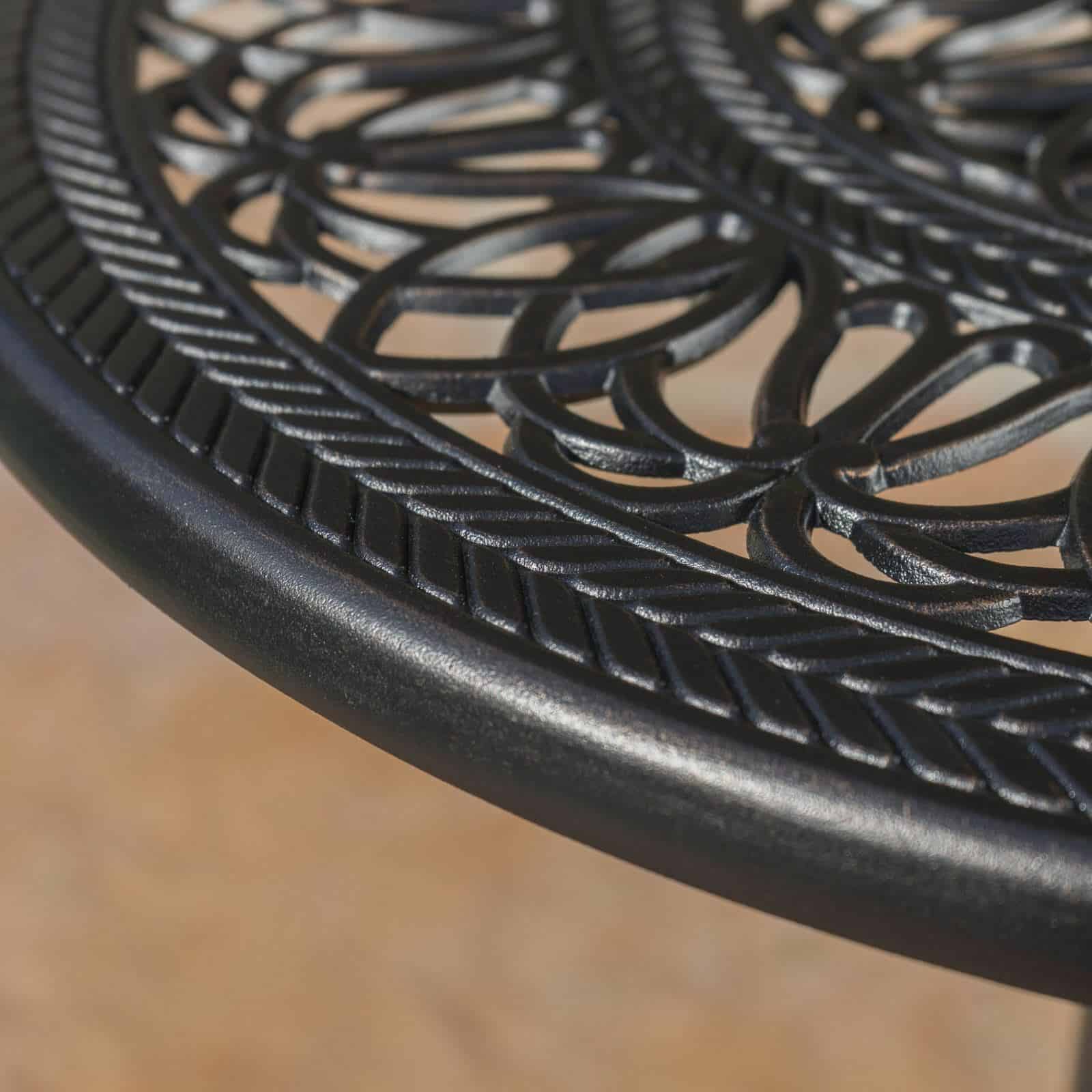 A close up of an outdoor table with an intricate design.