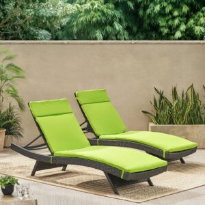 Two green chaise loungers on a patio.