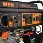 A black and orange portable wen 11000w dual fuel generator with wheels.