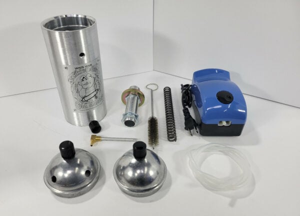 Various parts of a pneumatic tattoo machine set on a white surface.