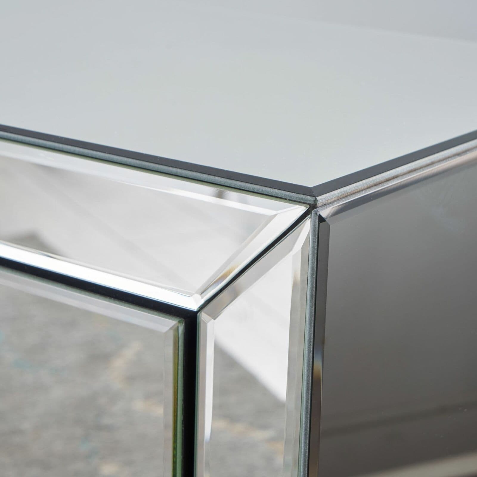 A close up of a mirrored side table.