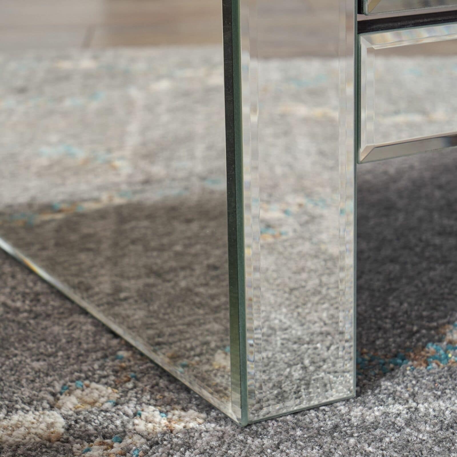 A glass coffee table with a mirror on top.