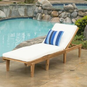 A wooden chaise lounge next to a pool.