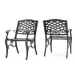 A pair of black wrought iron chairs on a white background.