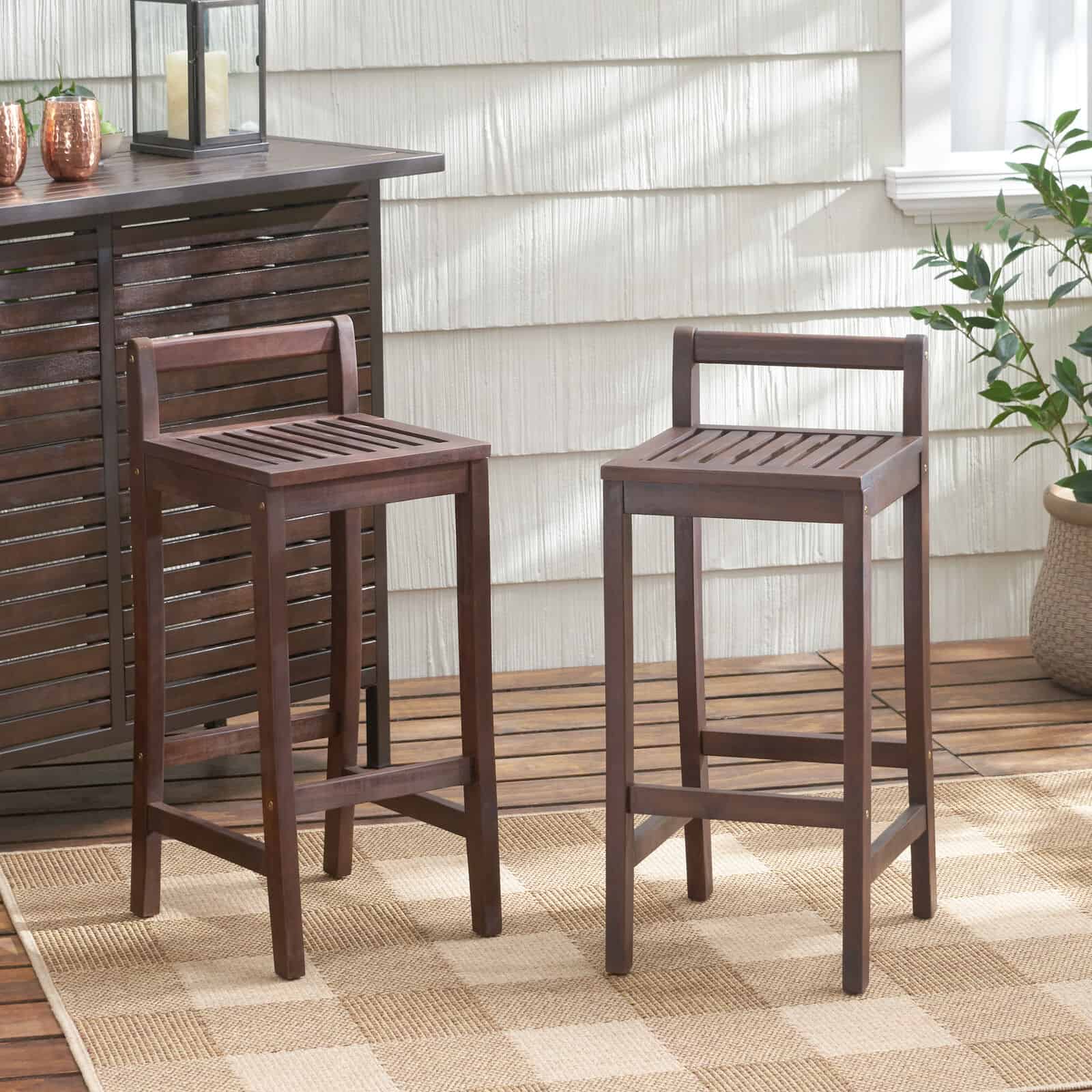 Two wooden bar stools on a wooden floor.