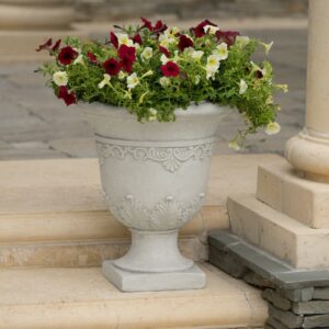 A white urn with red and white flowers on the steps.